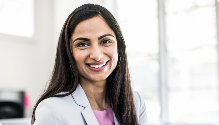 A woman in a professional jacket smiling.