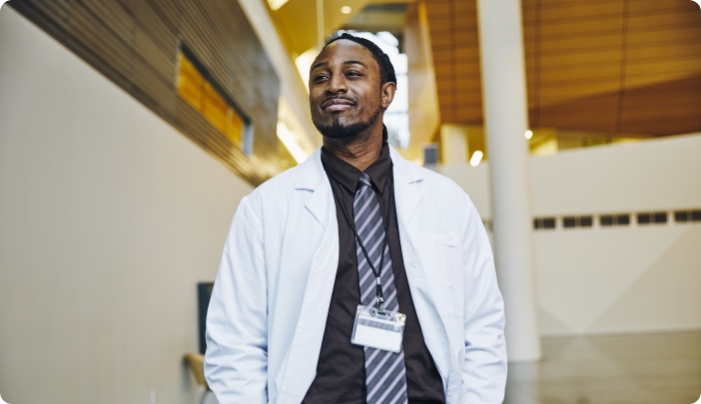 A doctor in a medical coat on and badge around his neck.